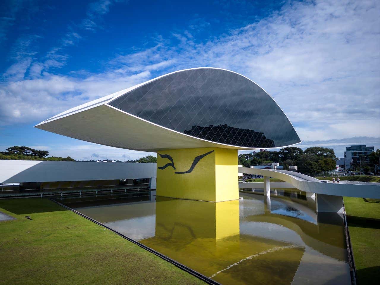 Museu Oscar Niemeyer visto de fora em formato de olho sobre um lago artificial