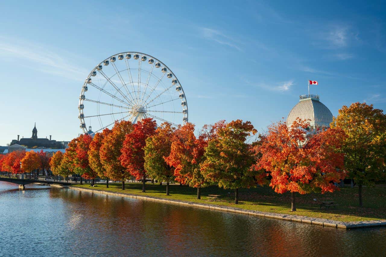 La ruota panoramica La Grande Roue a Montreal, osservata dall' altro lato del fiume con il cielo azzurro sullo sfondo.