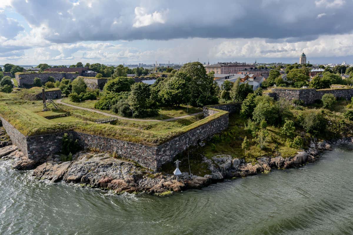 Vista aerea della costa di Helsinki con le rovine di un'antica fortezza in primo piano in una giornata molto nuvolosa