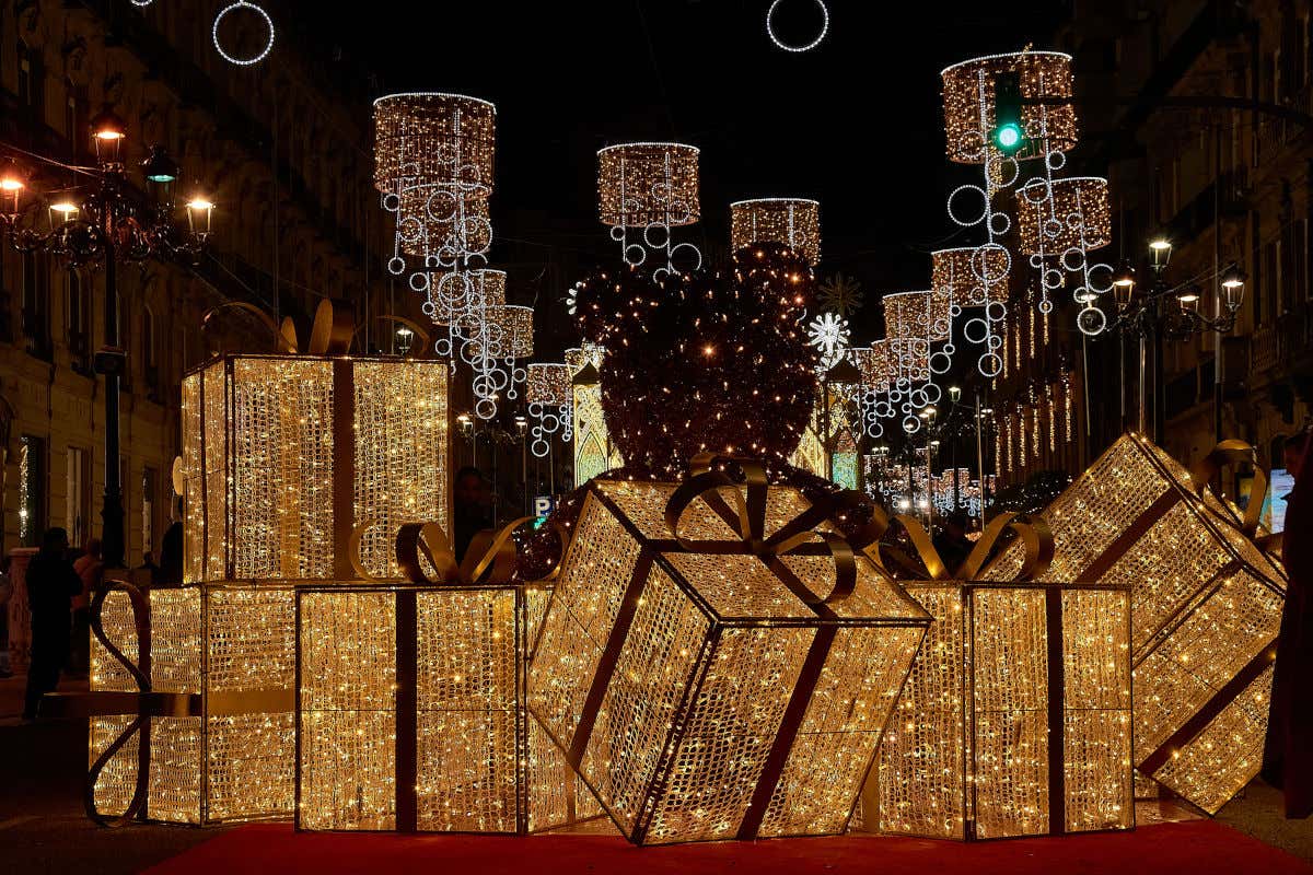 Large lit-up presents in a street as a Christmas decoration in Vigo with more Christmas lights in the background at night