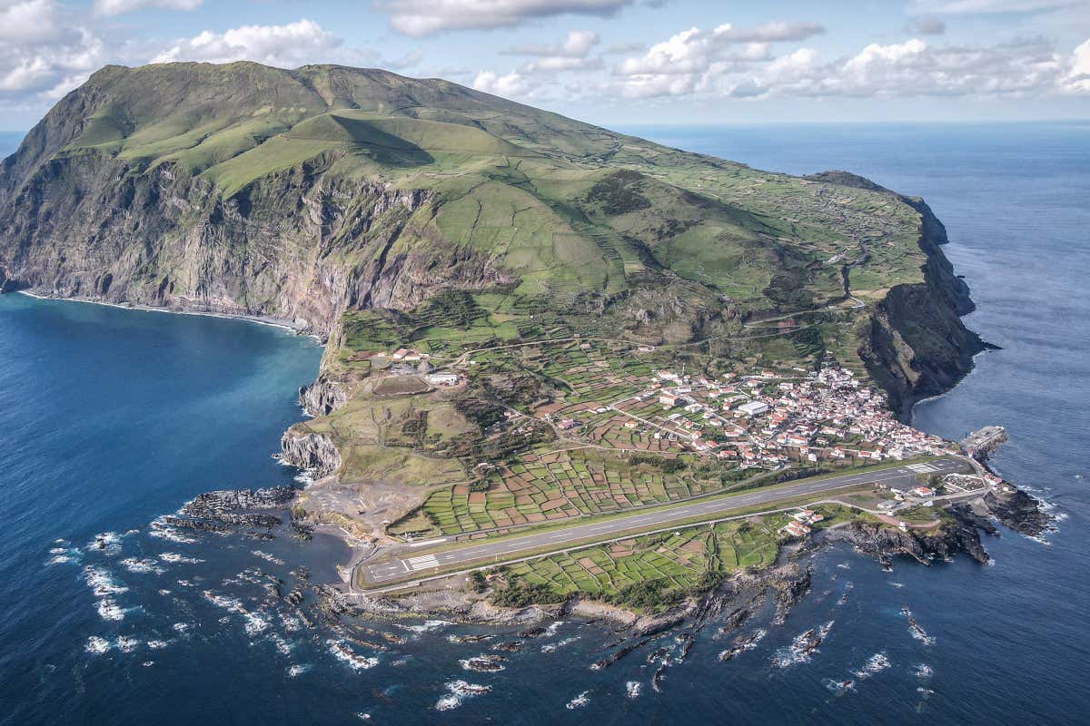 Vista aérea de una isla, con el aeropuerto y un pueblo en su zona más baja