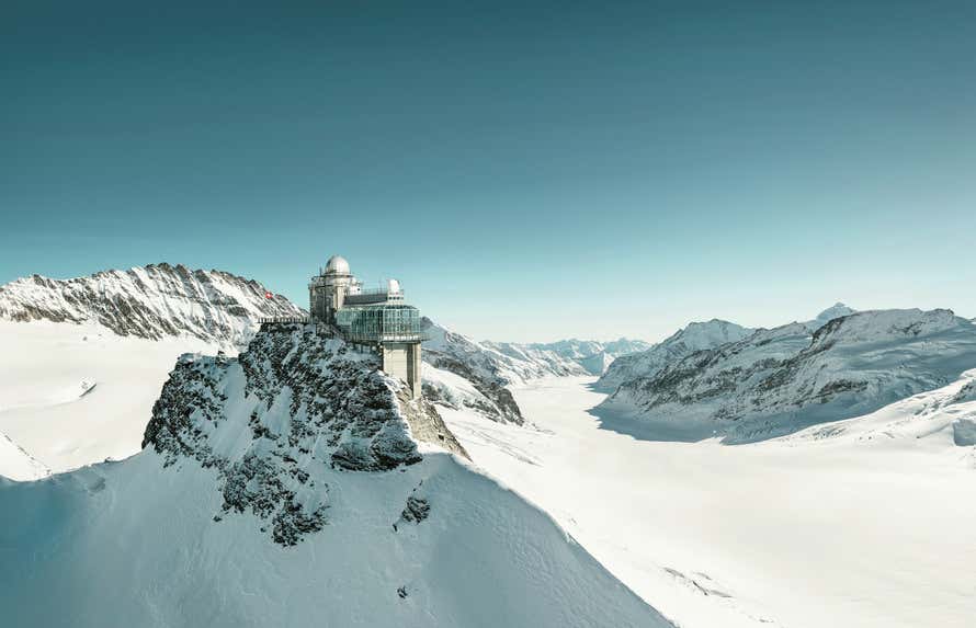 Panorámica de Jungfraujoch repleto de nieve con el cielo azul de fondo 