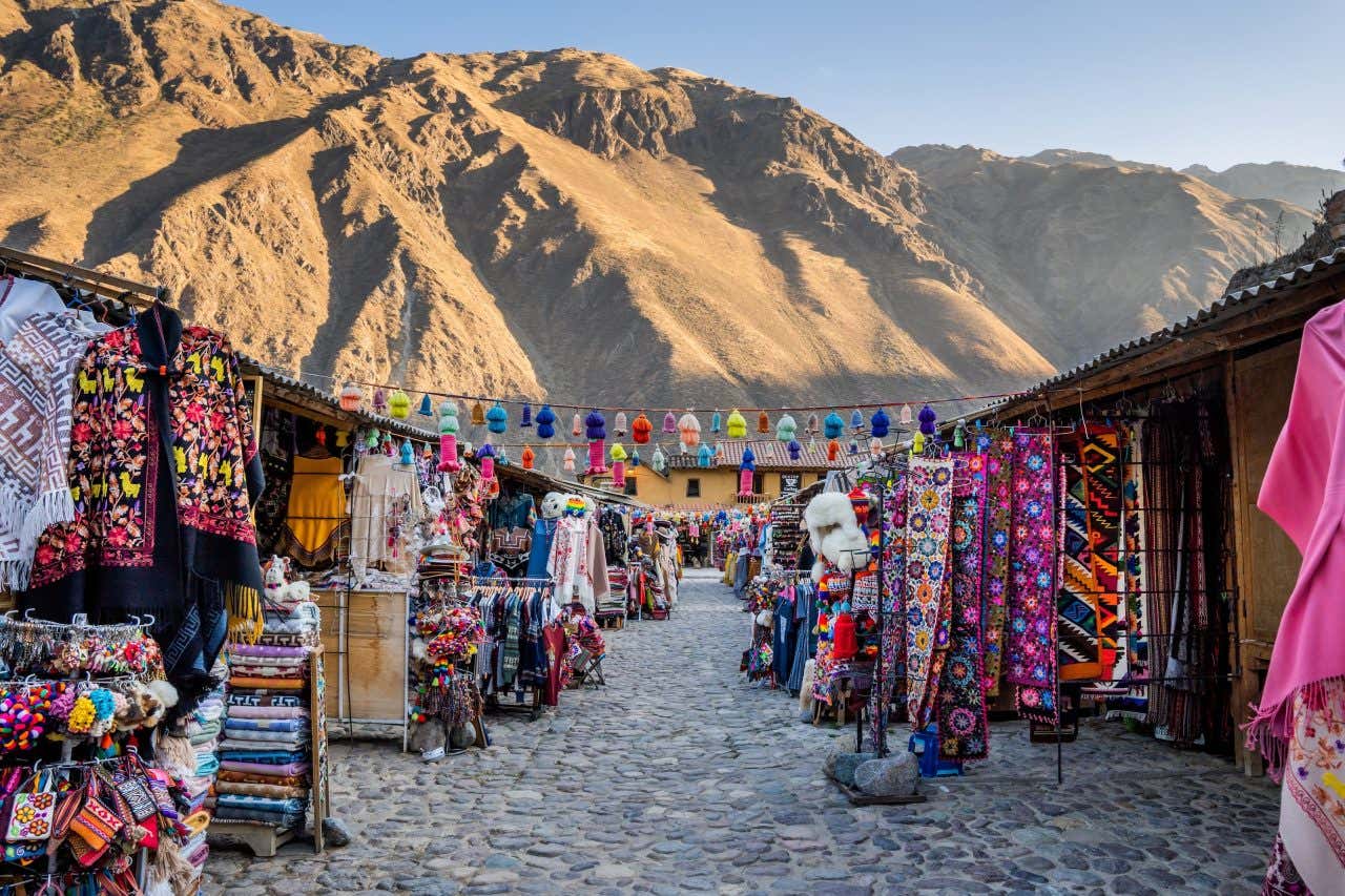 Mercado de artesanatos em Ollantaytambo com as montanhas andinas ao fundo