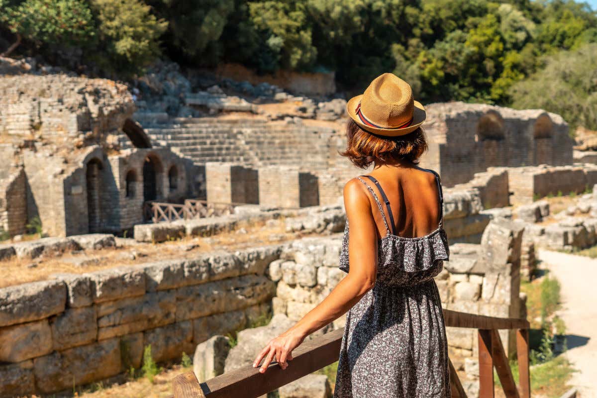 Una mujer de espaldas a la cámara contemplando las ruinas de uno de los yacimientos arqueológicos más importantes que ver en Albania