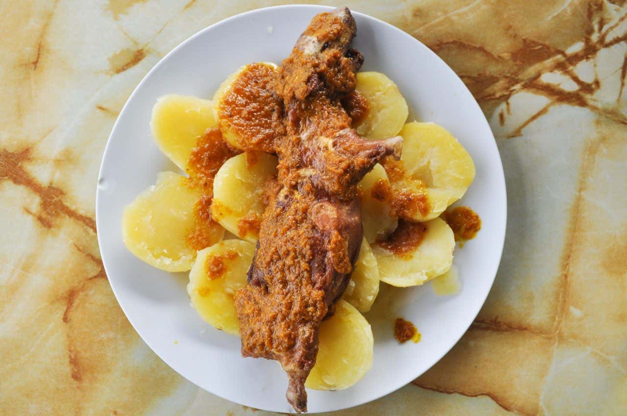 Prato com cuy chactado, porquinho-da-índia frito servido com batatas e molho de pimenta