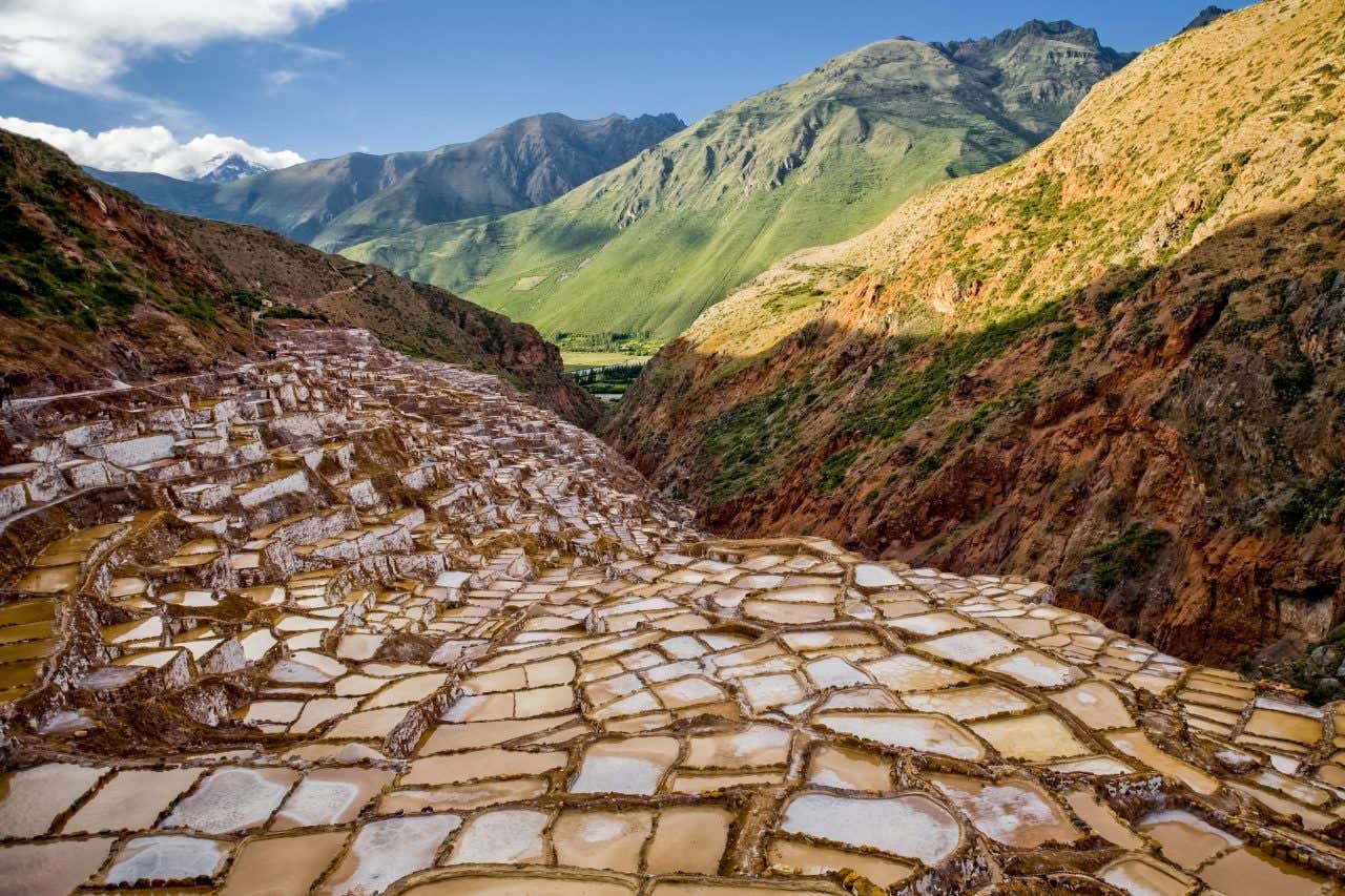 Paisagem única das salinas de Maras contrastando com os verdes as montanhas andinas.