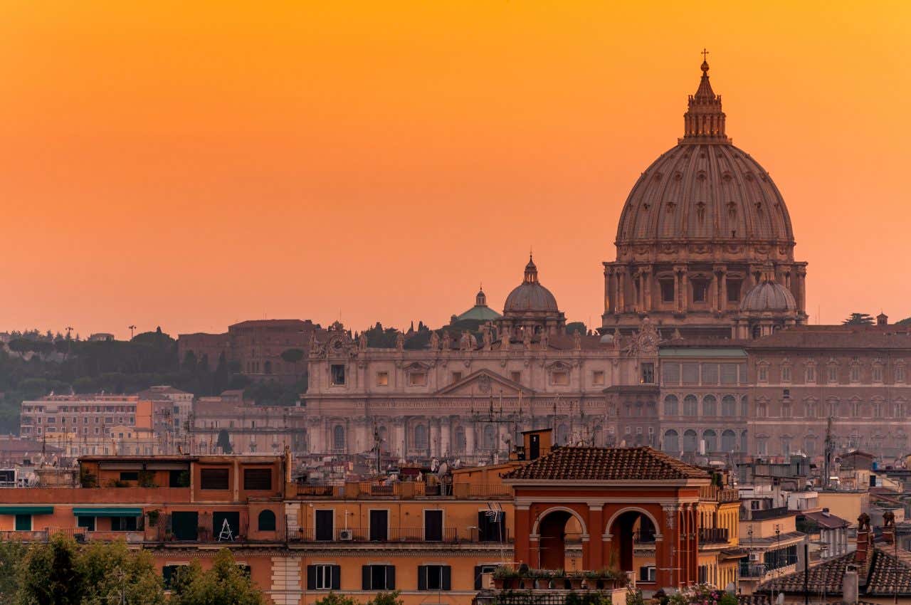 Coucher de soleil sur Rome avec vue sur le dôme de la basilique Saint-Pierre et un ciel orange, un spectacle idéal pour finir en beauté une visite de 3 jours à Rome