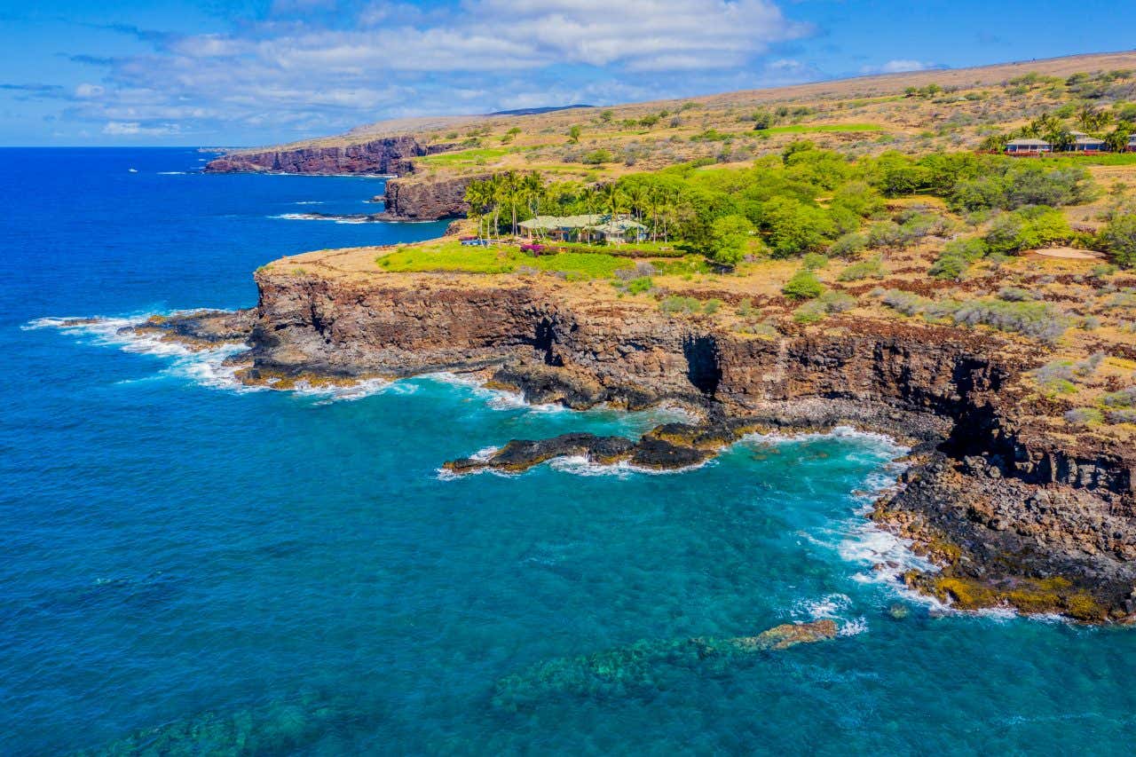 Lanai's coastline with green vegetation atop the cliffs.