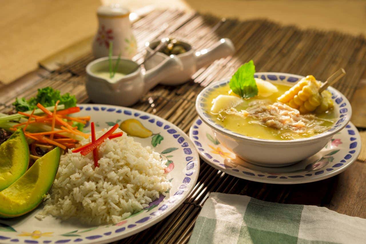 Prato típico de Bogotá, o ajiaco santafereño, uma sopa servida com arroz e abacate 