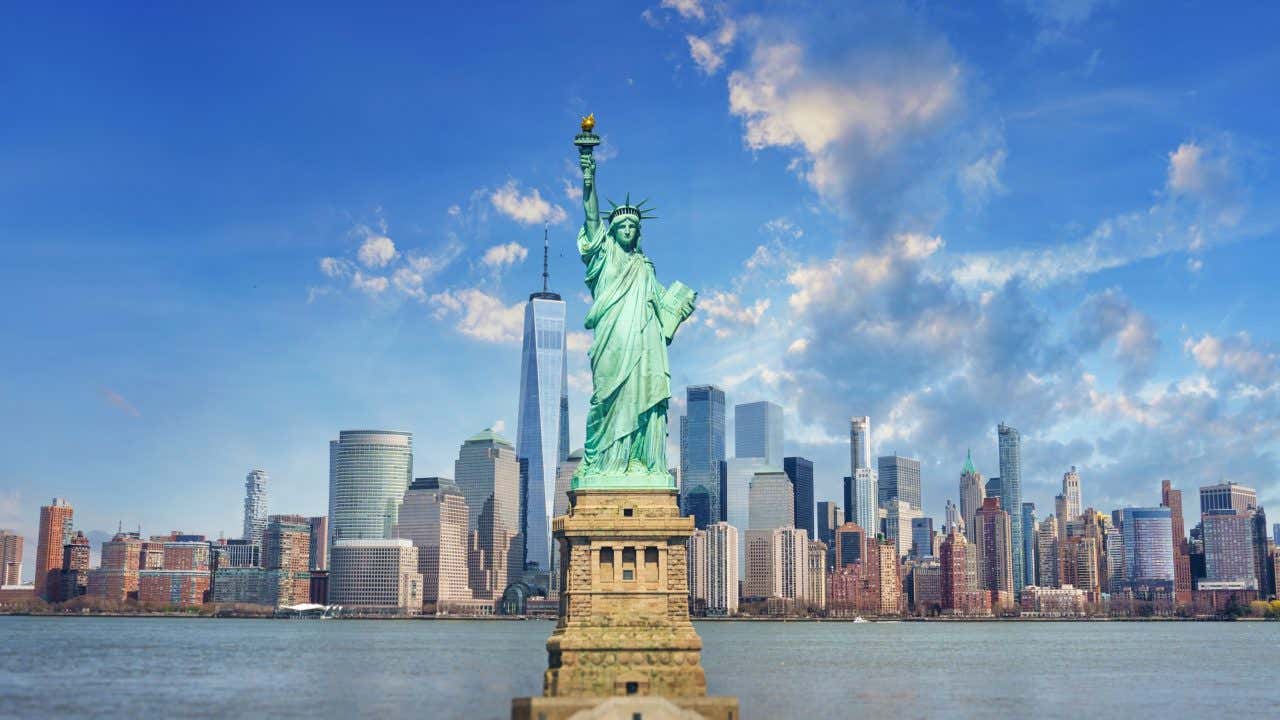 Vista da Estátua da Liberdade da Baía de Nova York, com Manhattan ao fundo