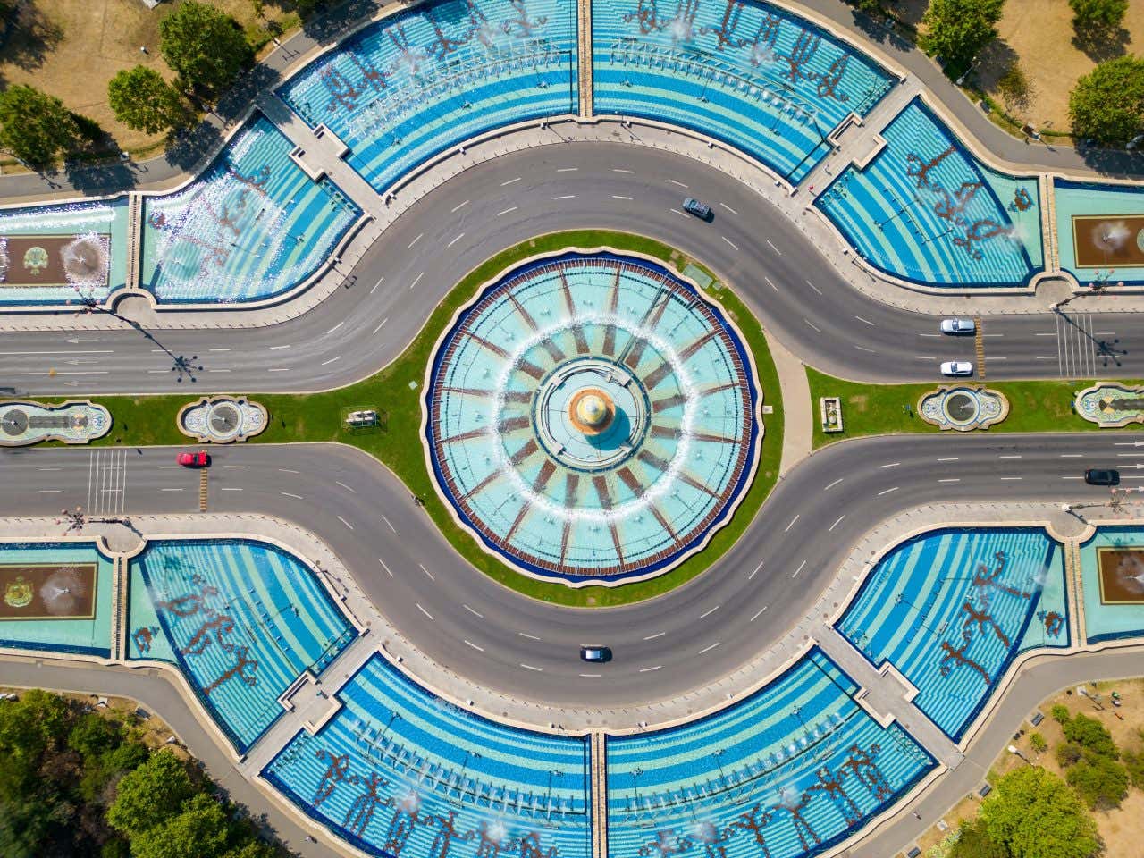 Vista aerea di un complesso di fontane circolari, la più piccola è al centro della piazza, mentre intorno ci sono altre vasche che formano due semicerchi che cingono da entrambi i lati la fonte centrale.