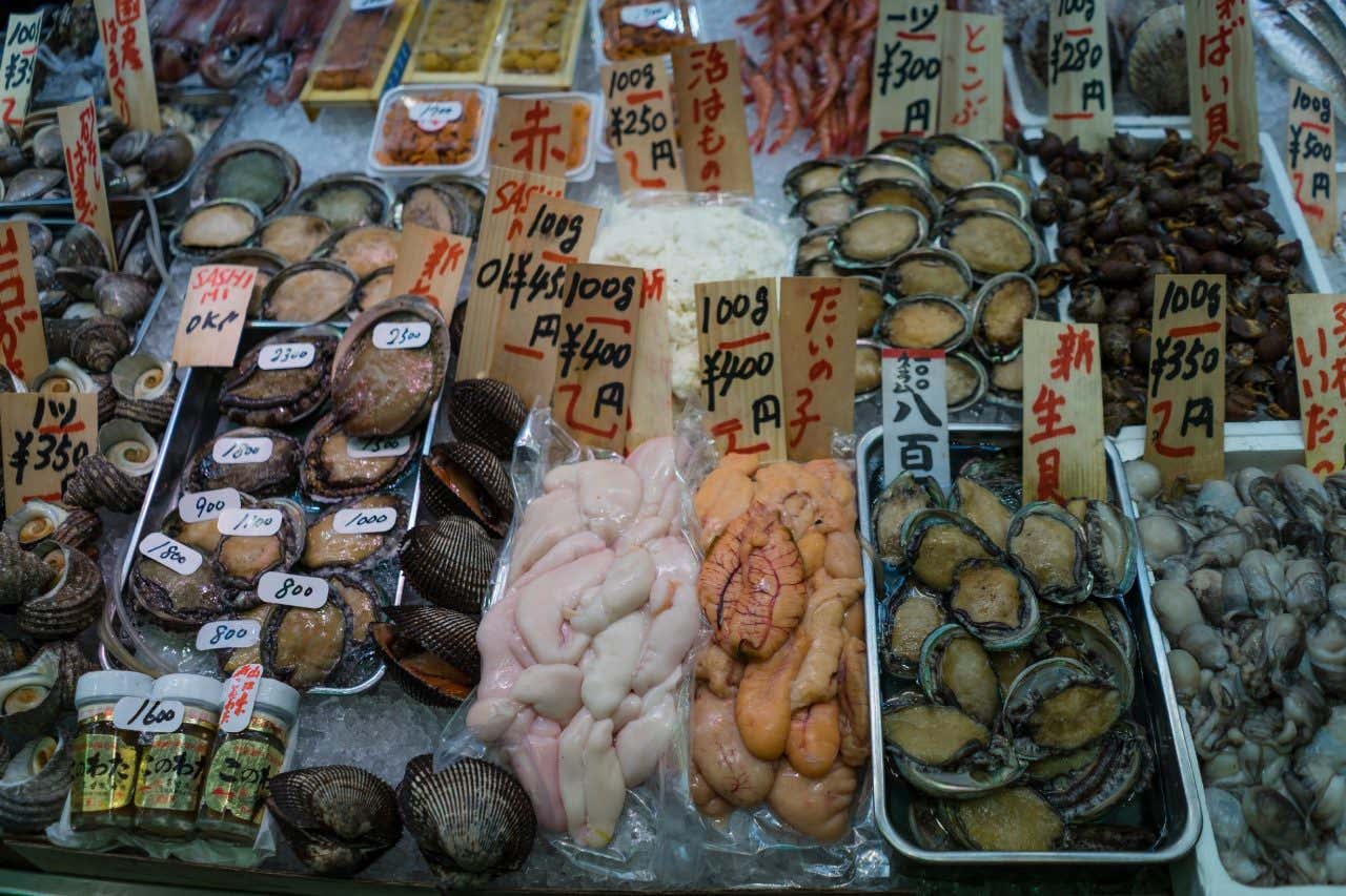 Fresh fish being sold in Nishiki Market, with prices on each box.