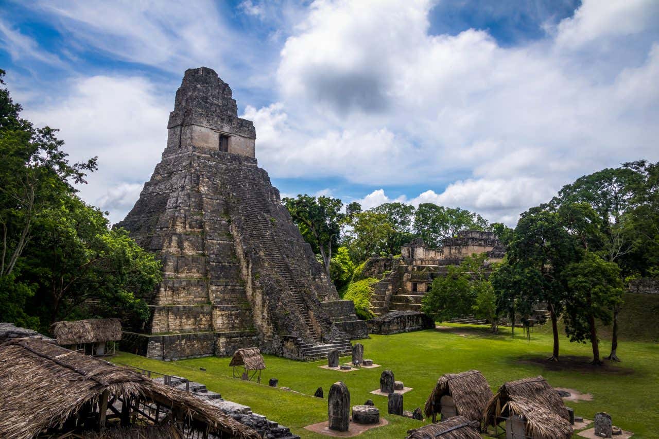 Site archéologique maya avec des pyramides précolombiennes et de l'herbe verte en bas