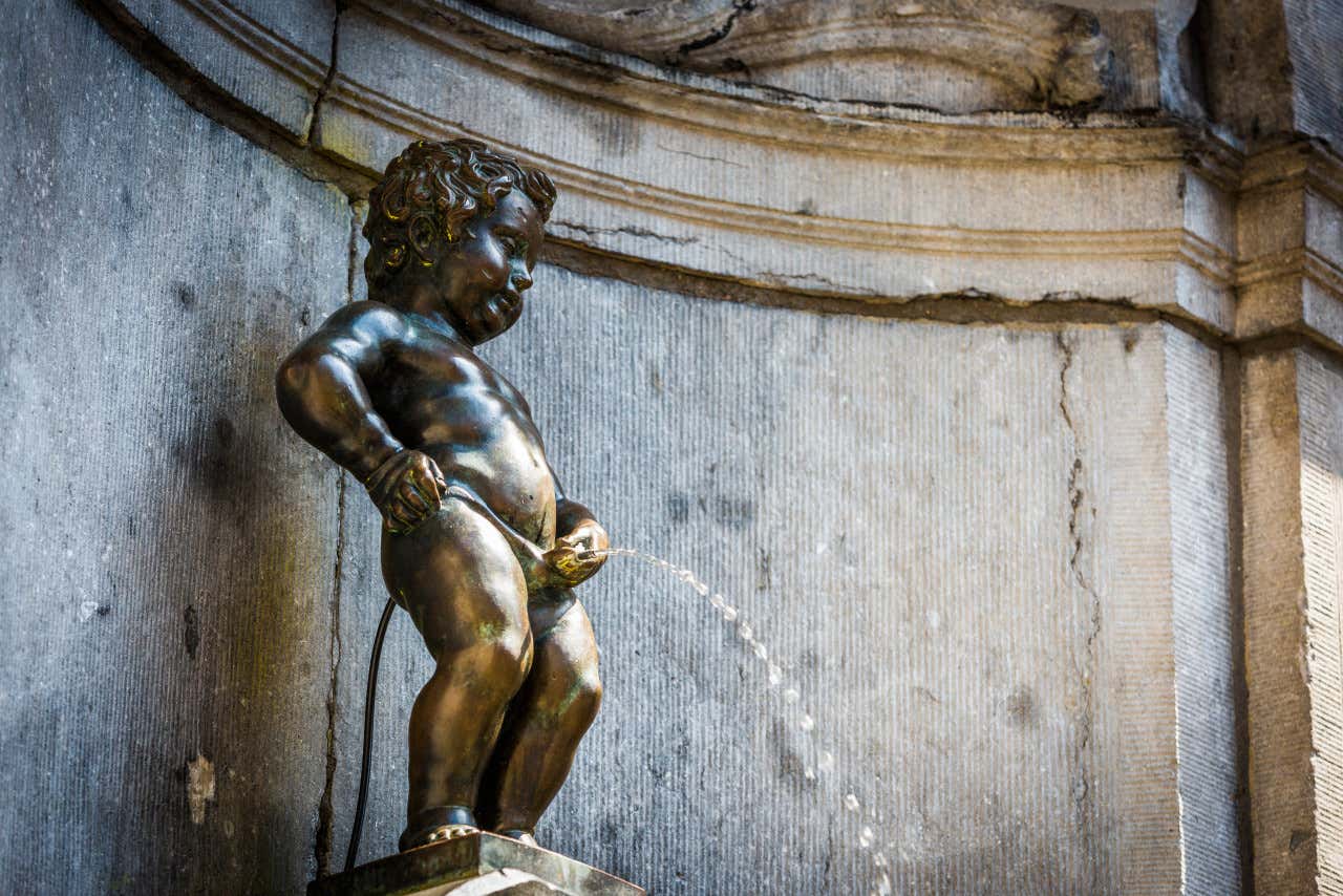 Primeiro plano da estátua de Manneken-Pis, uma criança fazendo xixi