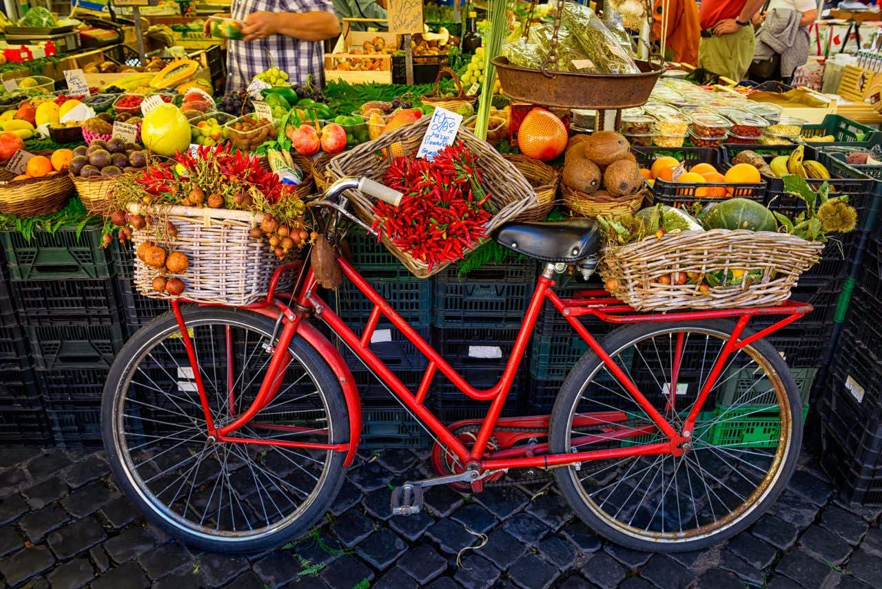 Étale de fruits et légumes au marché de Campo de' Fiori avec un vélo rouge