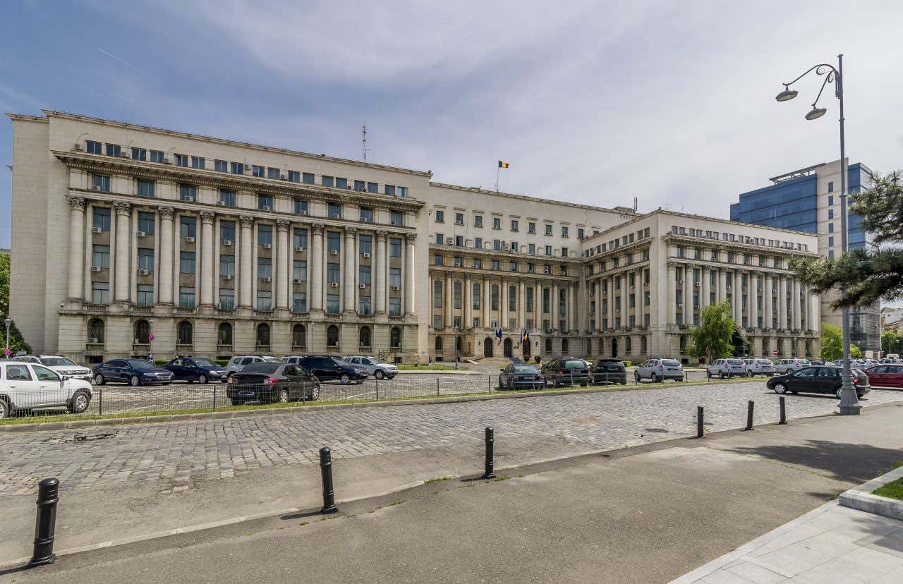 Un grosso edificio rettangolare sormontato dalla bandiera della Romania