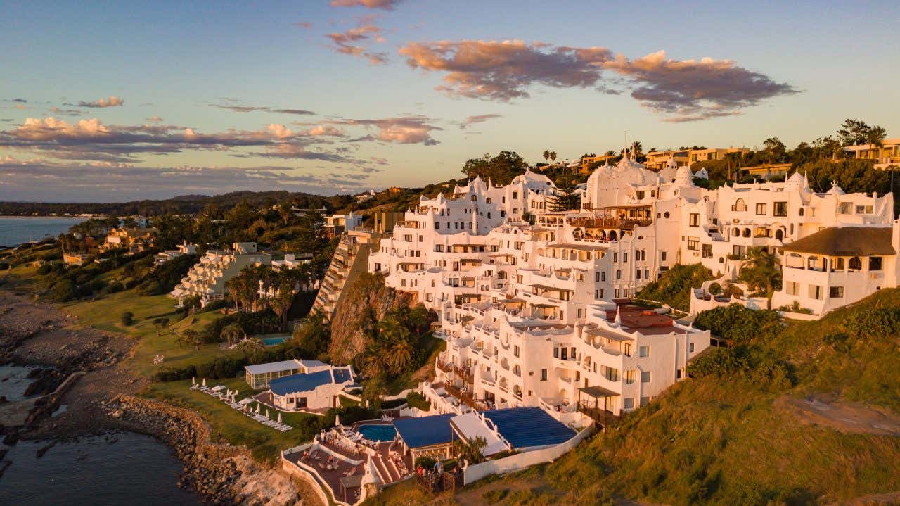 Panorâmica da Casapueblo, uma grande construção de paredes brancas em um penhasco