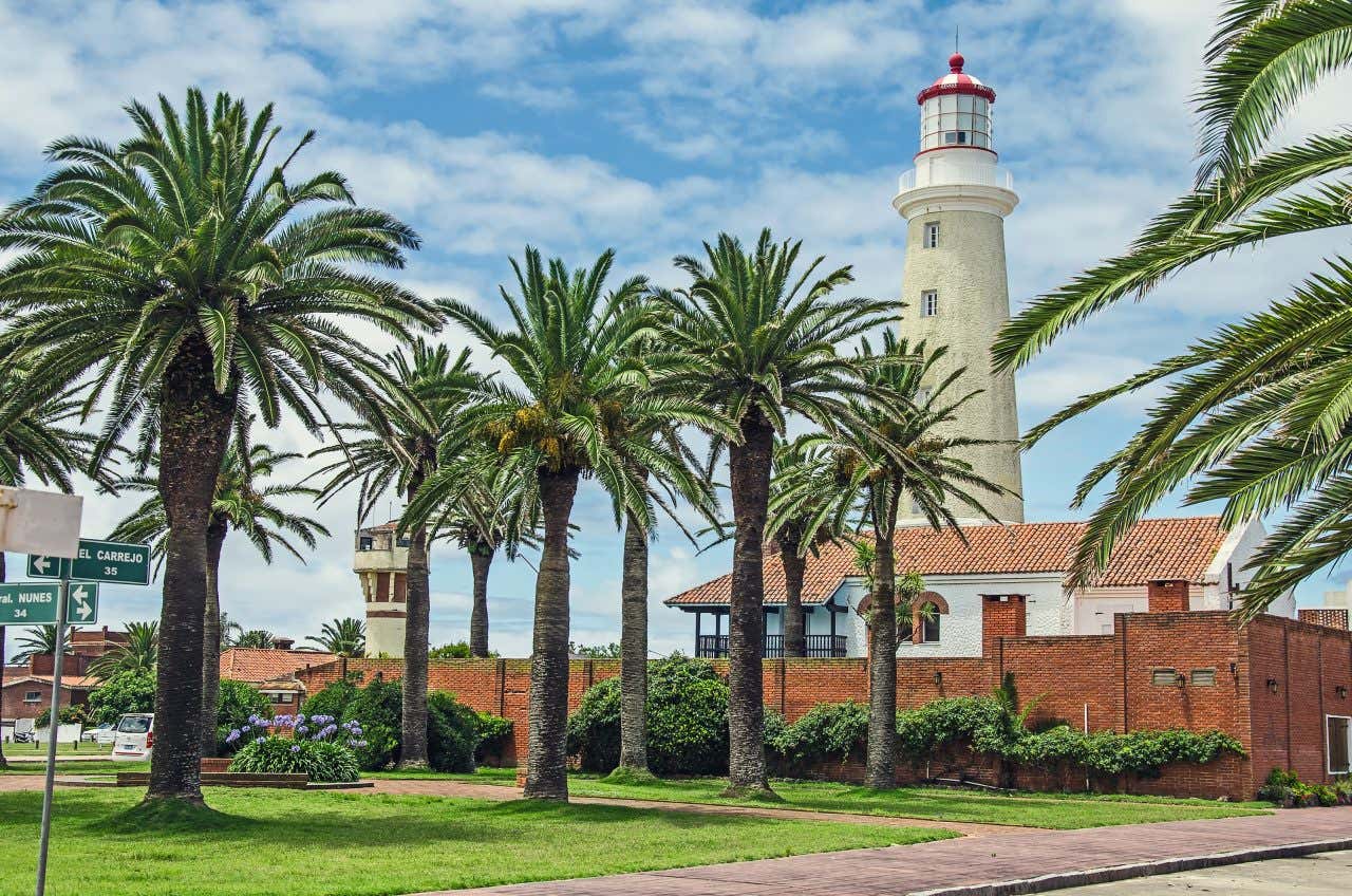 O farol de Punta del Este ao fundo de um cenário de palmeiras