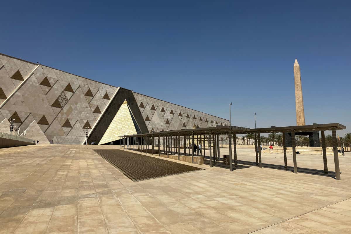 Exteriors of the Great Egyptian Museum with an obelisk in its square.