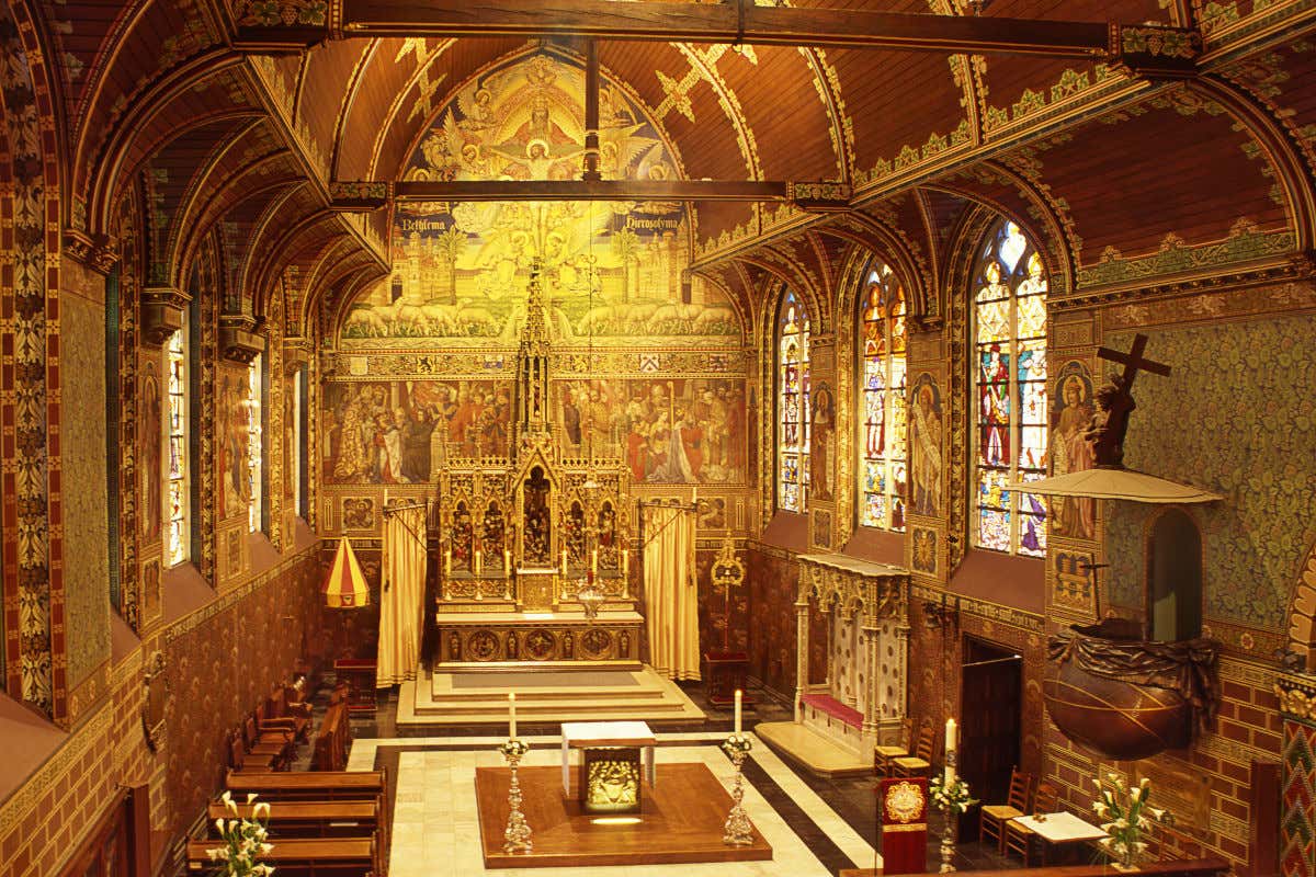 Interior de la basílica de la Santa Sangre, con sus techos de madera y su decorado altar con frescos