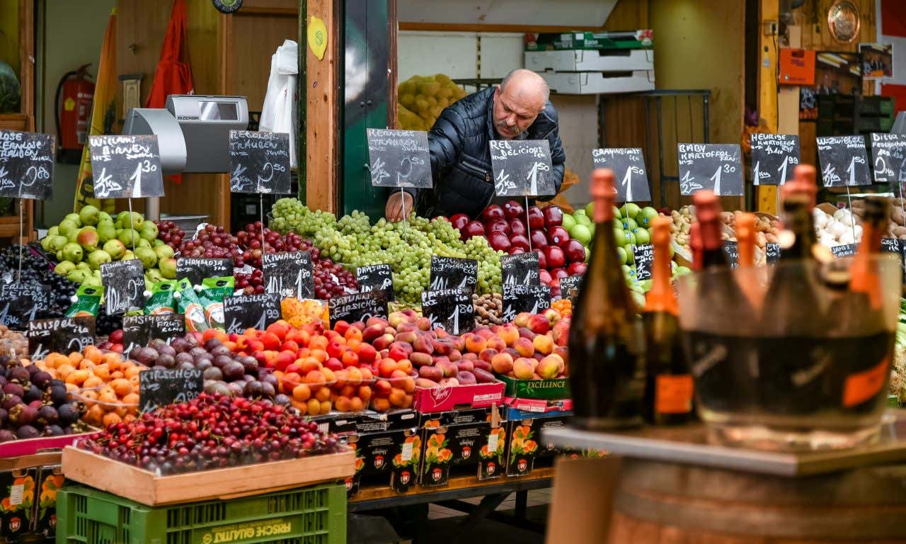 A man selling fruit at an open-aired market stand