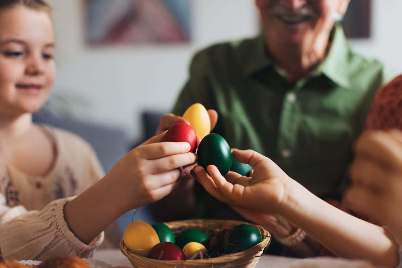 Família trocando ovos de Páscoa coloridos