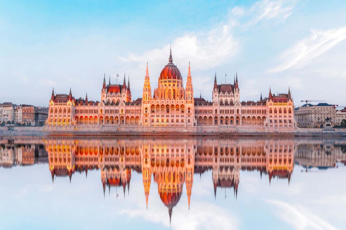 El Parlamento de Budapest reflejándose en las aguas del río Danubio con su cúpula y sus numerosos pináculos