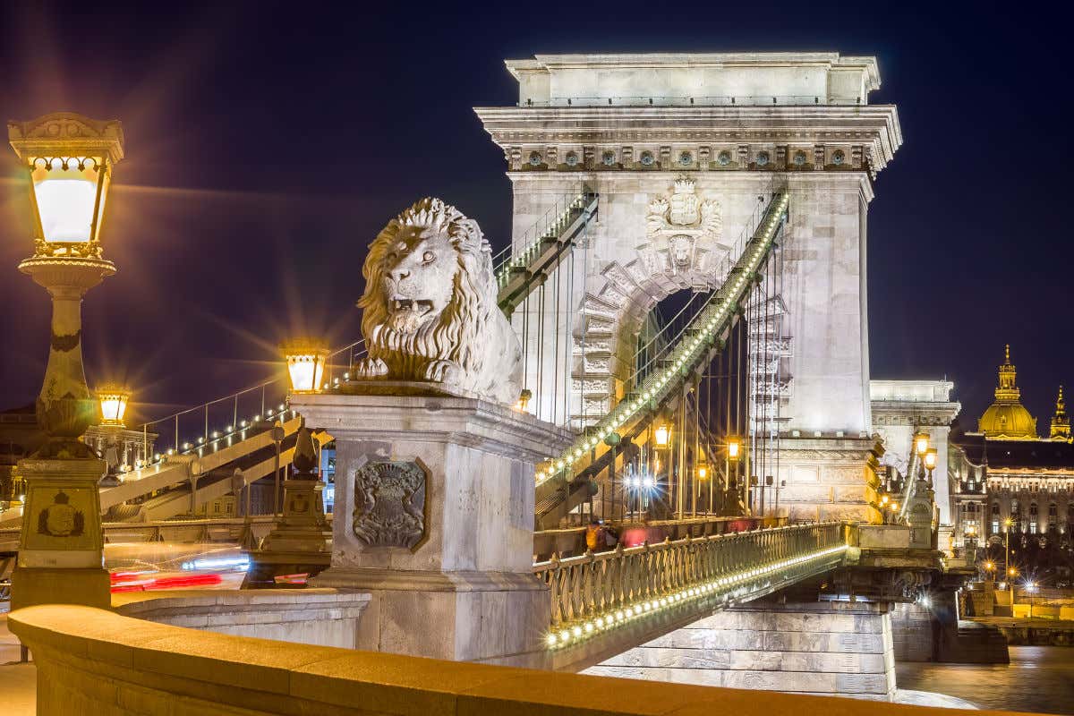 El puente de las Cadenas con sus arcos de piedra y sus esculturas de leones iluminados por la noche