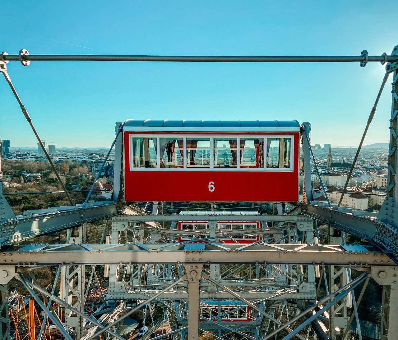 Views of the city seen from a giant Ferris Wheel with red cars