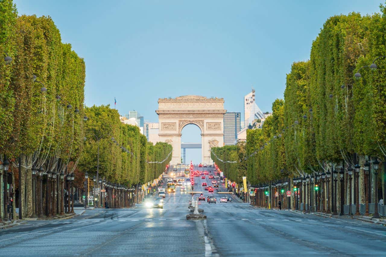 The Champs-Élysées in Paris, lined with trees and with the Arc de Triomphe in the background.