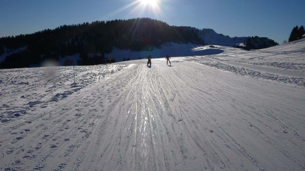 Skieurs de fond sous le soleil et sur une piste de La Clusaz, en France