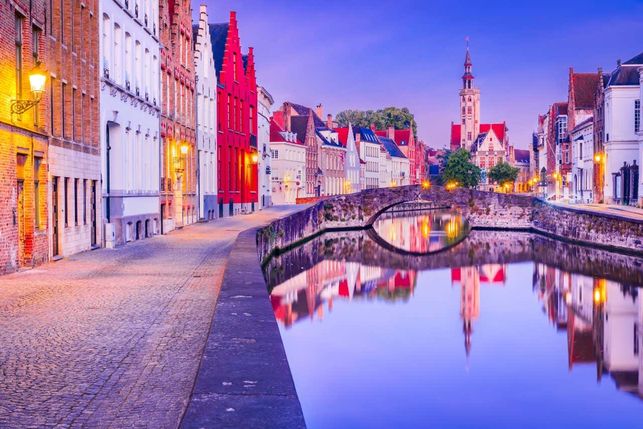 Un canal de Bruges à la tombée de la nuit, les bâtiments se reflètent dans l'eau