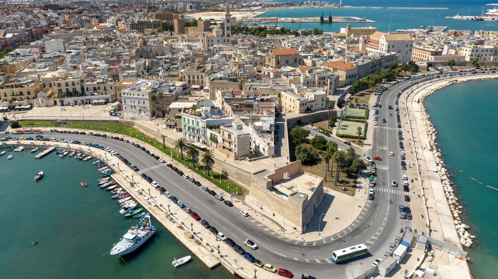 Vista aerea del lungomare di Bari con i palazzi del centro storico, le mura di cinta interrotte da un piccolo bastione in pietra