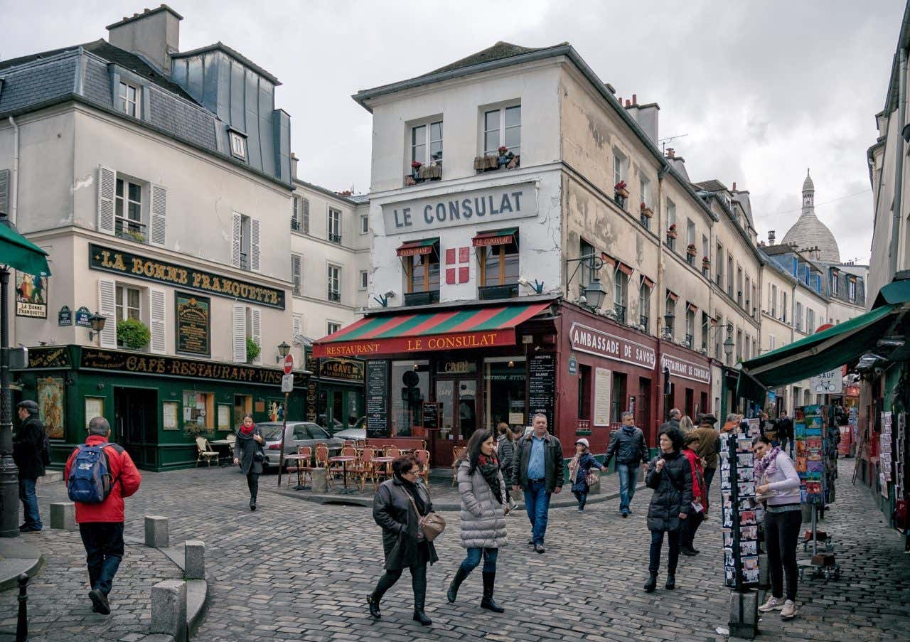 A shopfront with a sign that reads 'LE CONSULAT' in the streets of Montmartre.