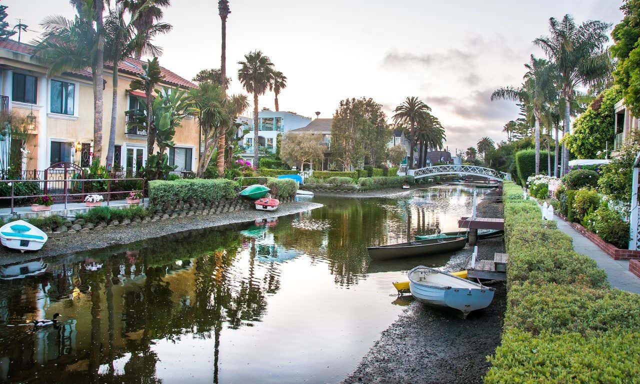 An artificial canal with moored boats and houses on the banks