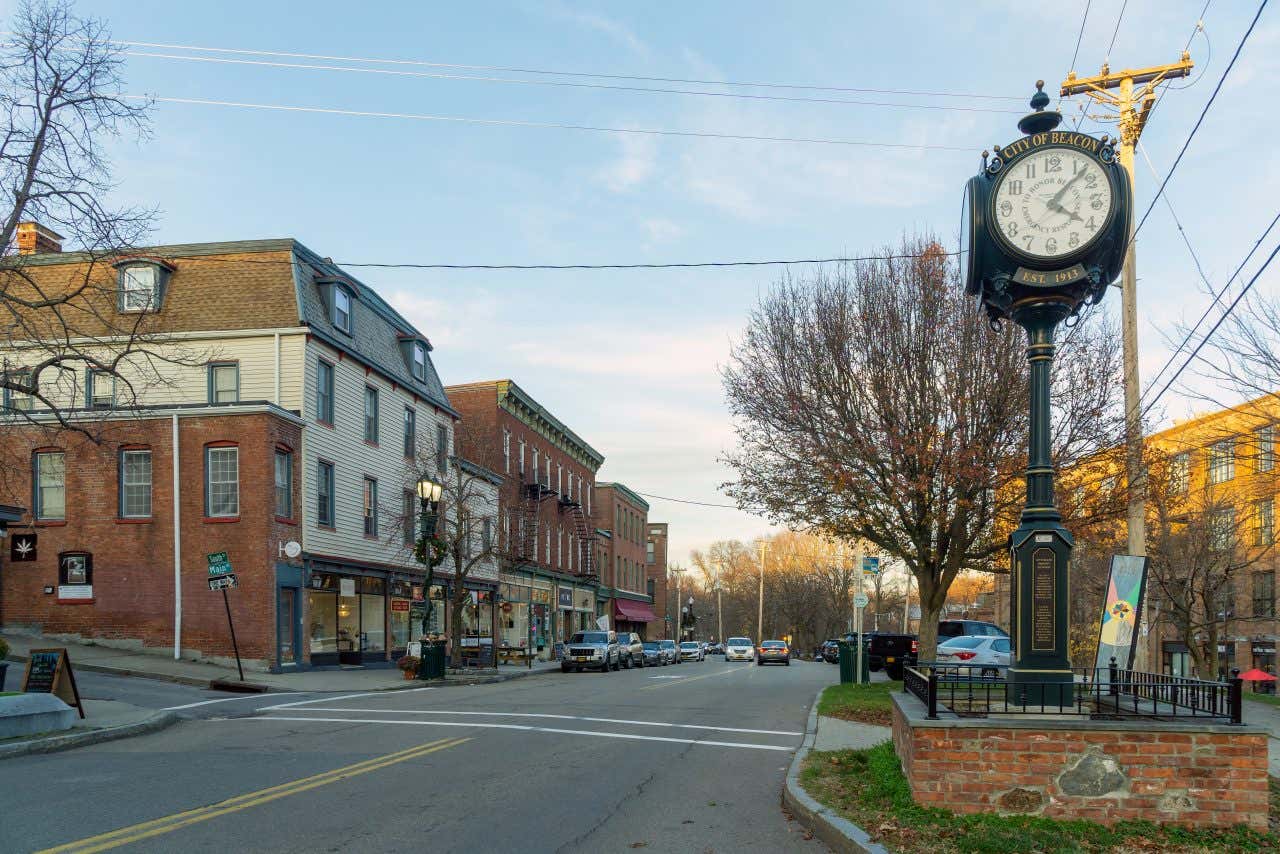 A street in Beacon, NY, with a clock on the right hand side and a blue sky in the background.