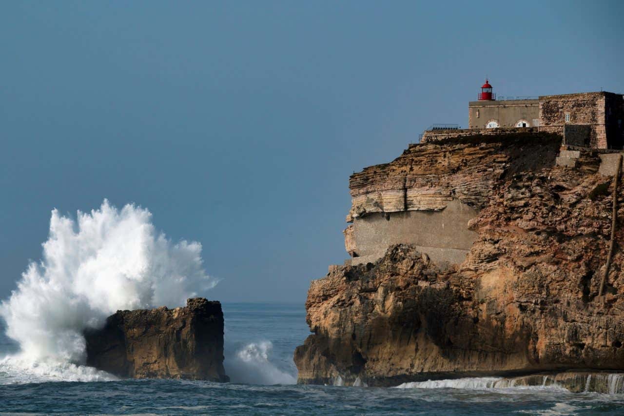 Duas grandes rochas com ondas arrebentando em uma delas