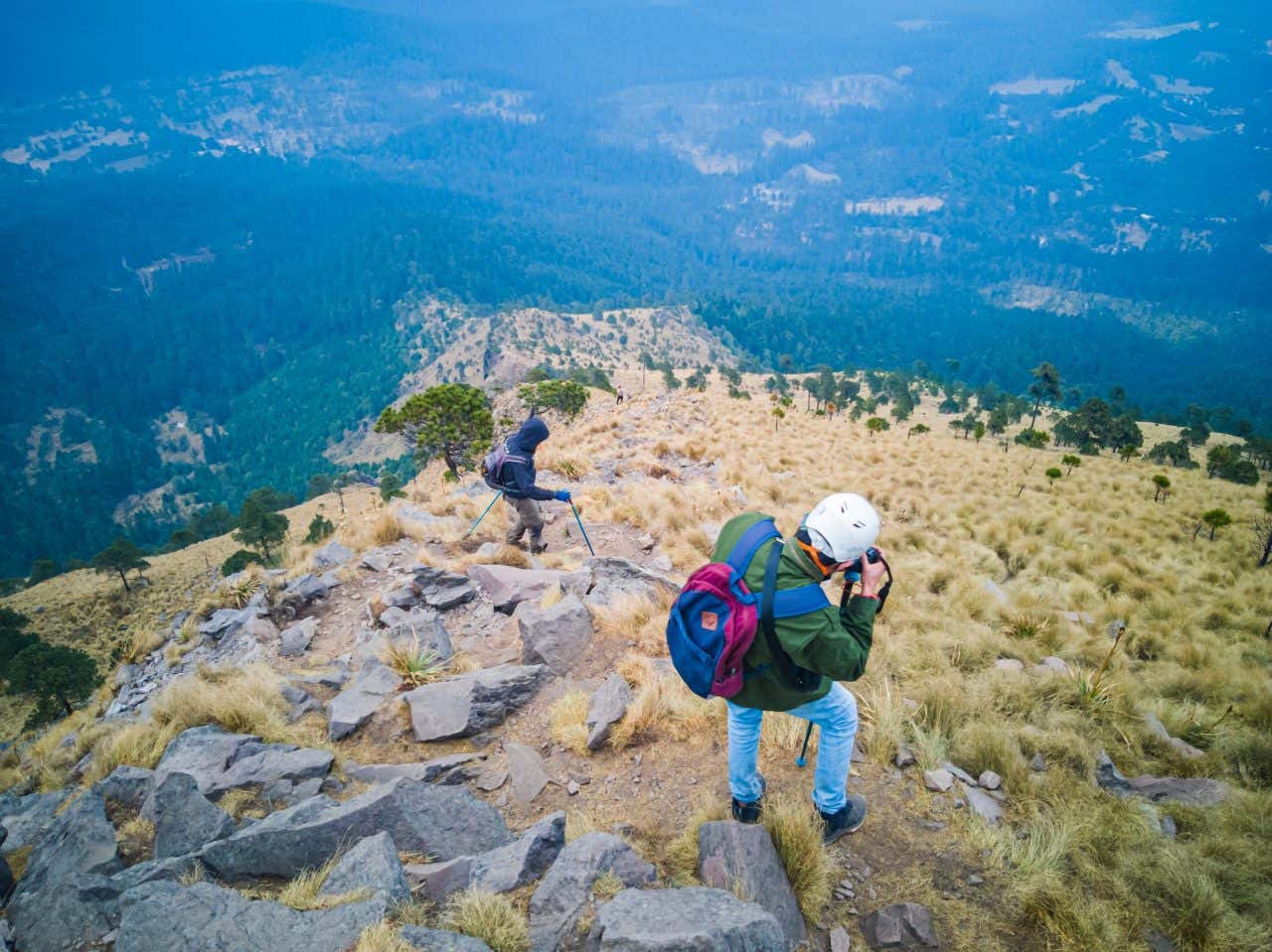 2 tourists walking in El Ajusco, looking down the mountain. 