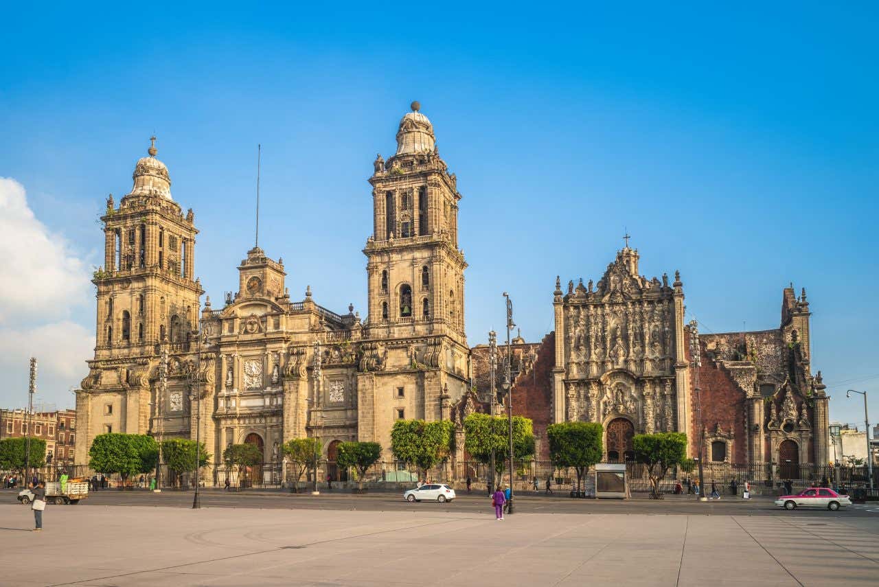 Mexico City Metropolitan Cathedral as seen from across the road with a mostly clear blue sky in the background.