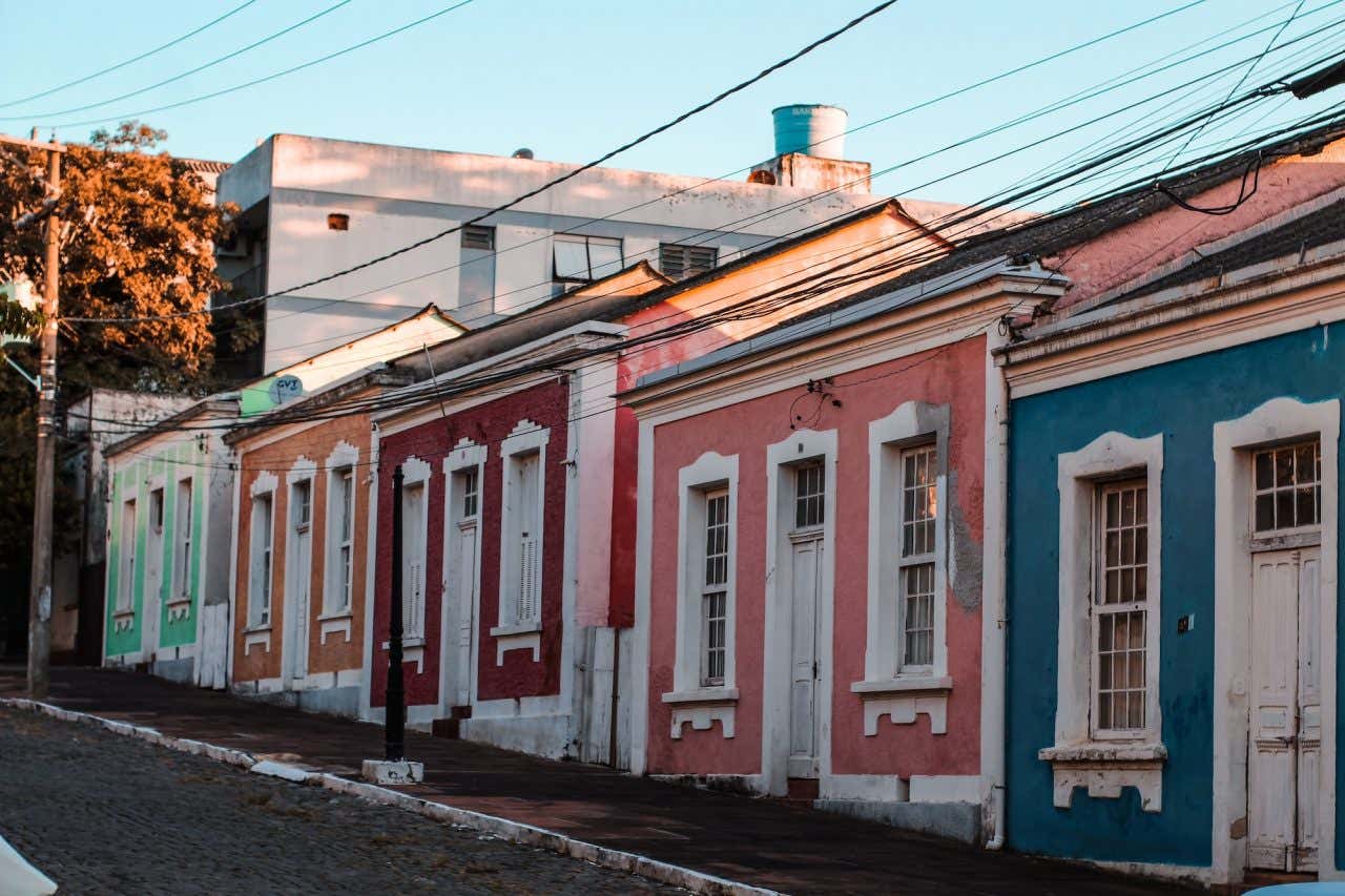 Rua de paralelepípedos com casas antigas pintadas de várias cores