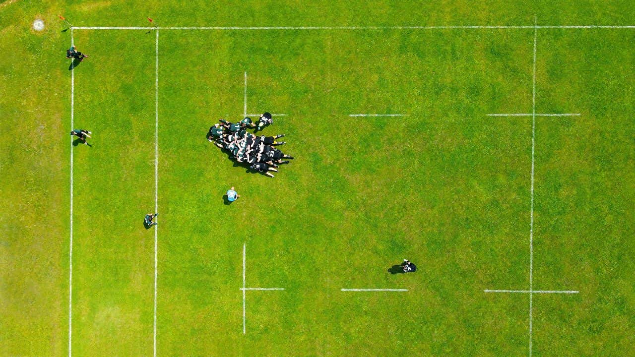 Terrain de rugby vu du dessus avec des joueurs dans une mêlée