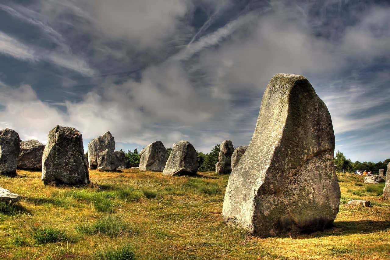 Les menhirs de Carnac sous un ciel nuageux et mystérieux, une visite à faire absolument en Bretagne