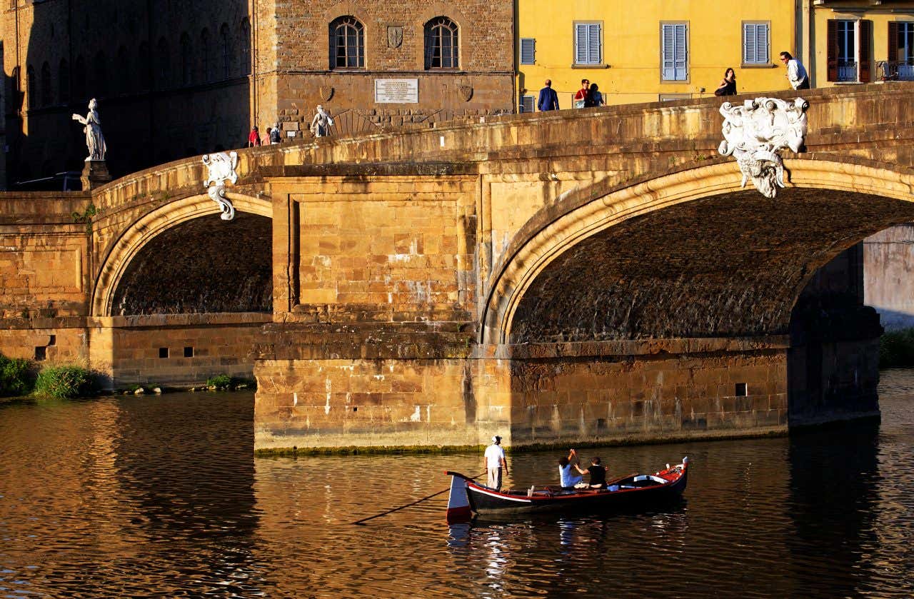 Gondole sur le fleuve Arno, passant sous un pont à Florence