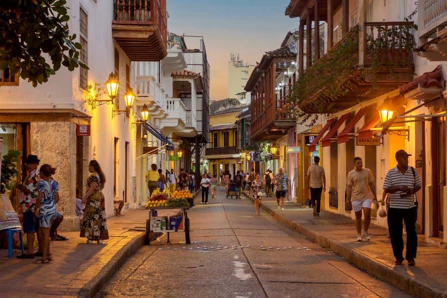 An evening in Cartagena Colombia in warm light with lots of people walking botht ways.