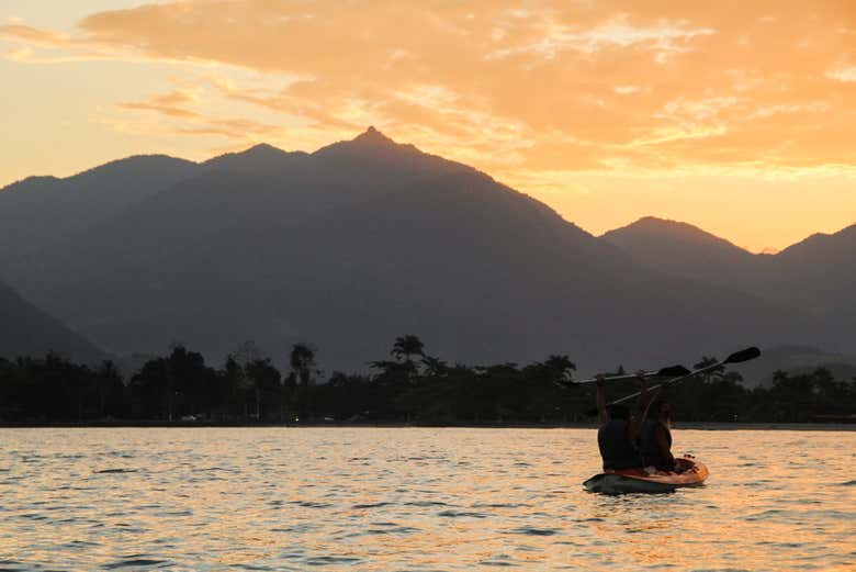 Casal remando ao pôr do sol. Muito romântico!