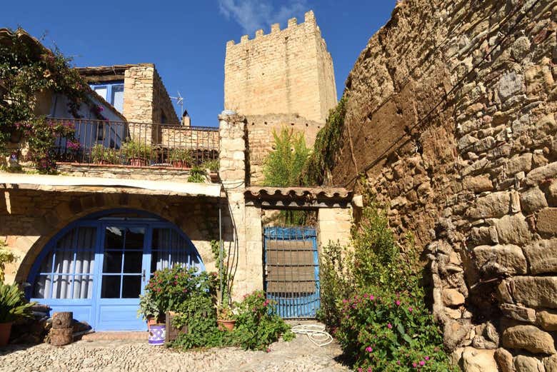 Una casa típica de Peratallada con la torre del castillo detrás