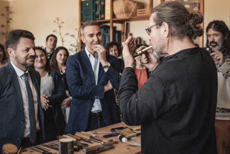 O artesão tocando um instrumento feito de madeira de agave