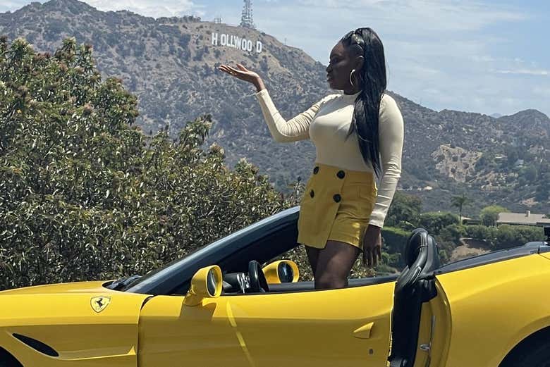 Posing in the Ferrari with the Hollywood sign in the background