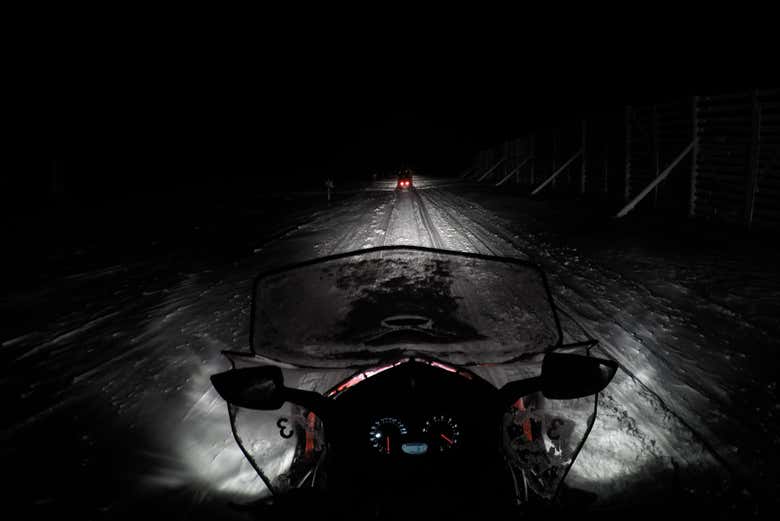 Conduciendo una moto de nieve por la noche