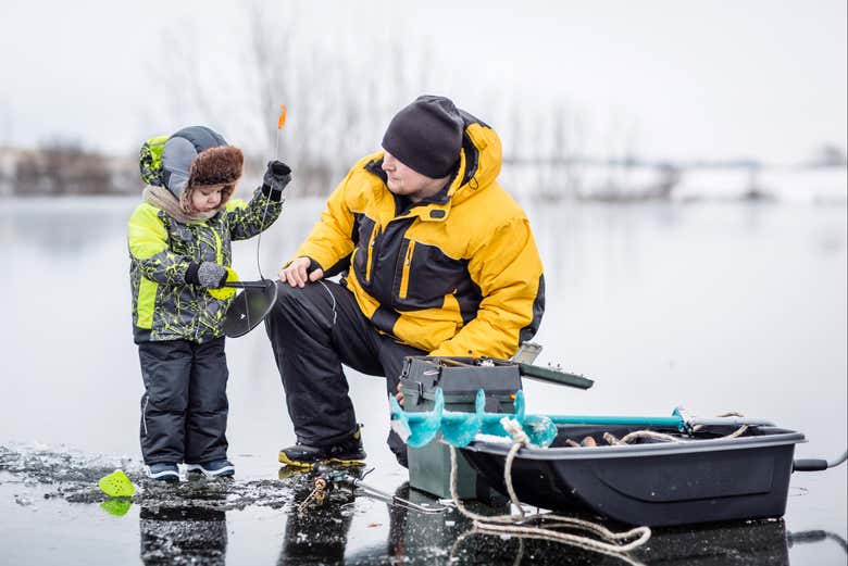 Un padre e un figlio mentre pescano sul ghiaccio